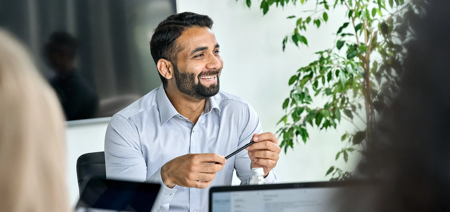 Happy male worker sat a desk in a modern office space