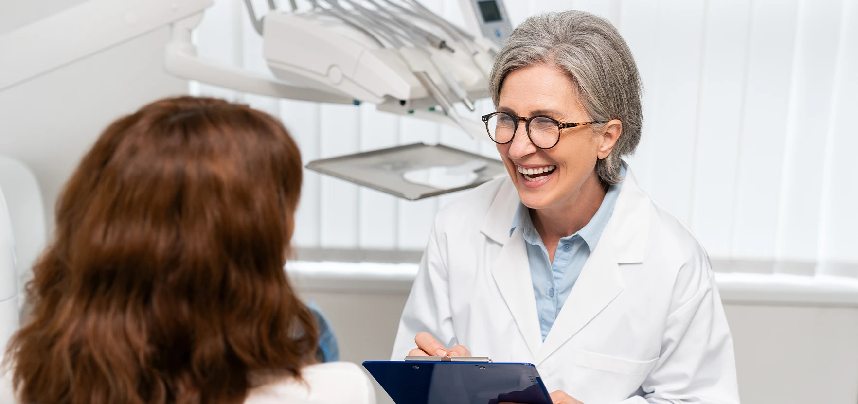 A female dentist smiling at a patient